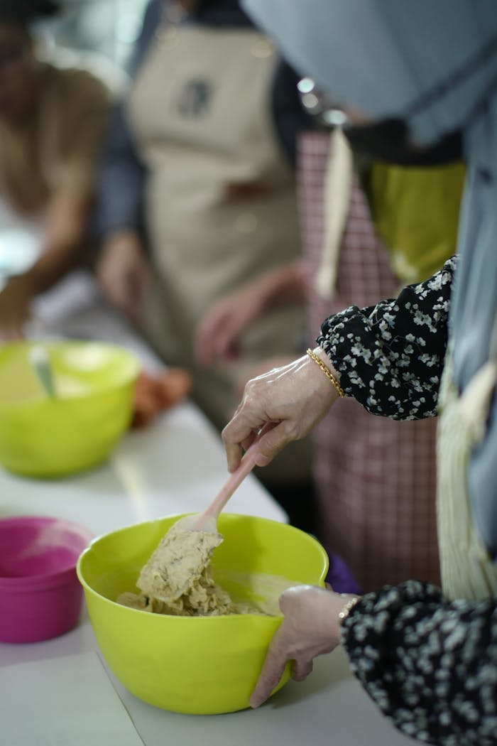 Women mixing dough during a baking class in Malaysia, hands-on learning.