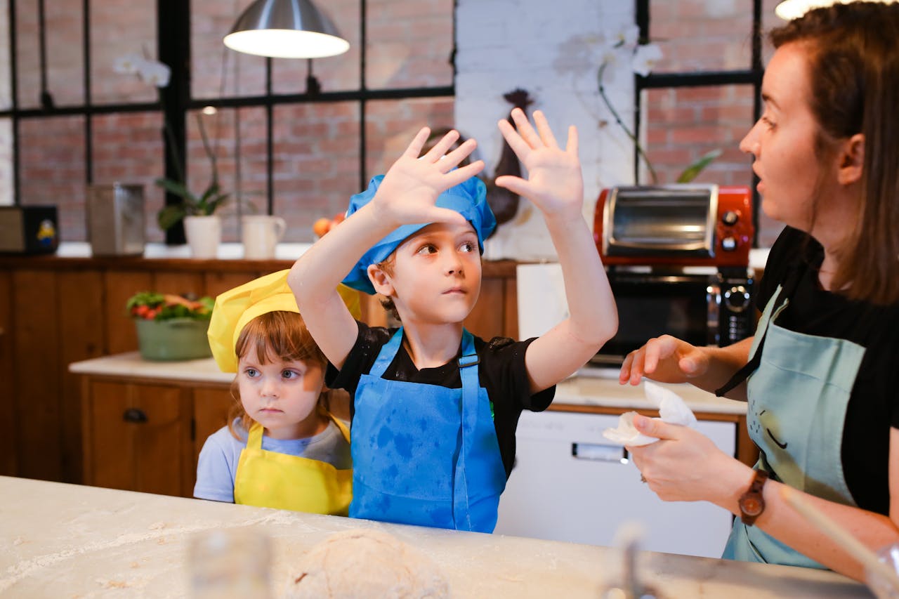 Home Kids having fun in a baking class, learning to make cookies together with an instructor.