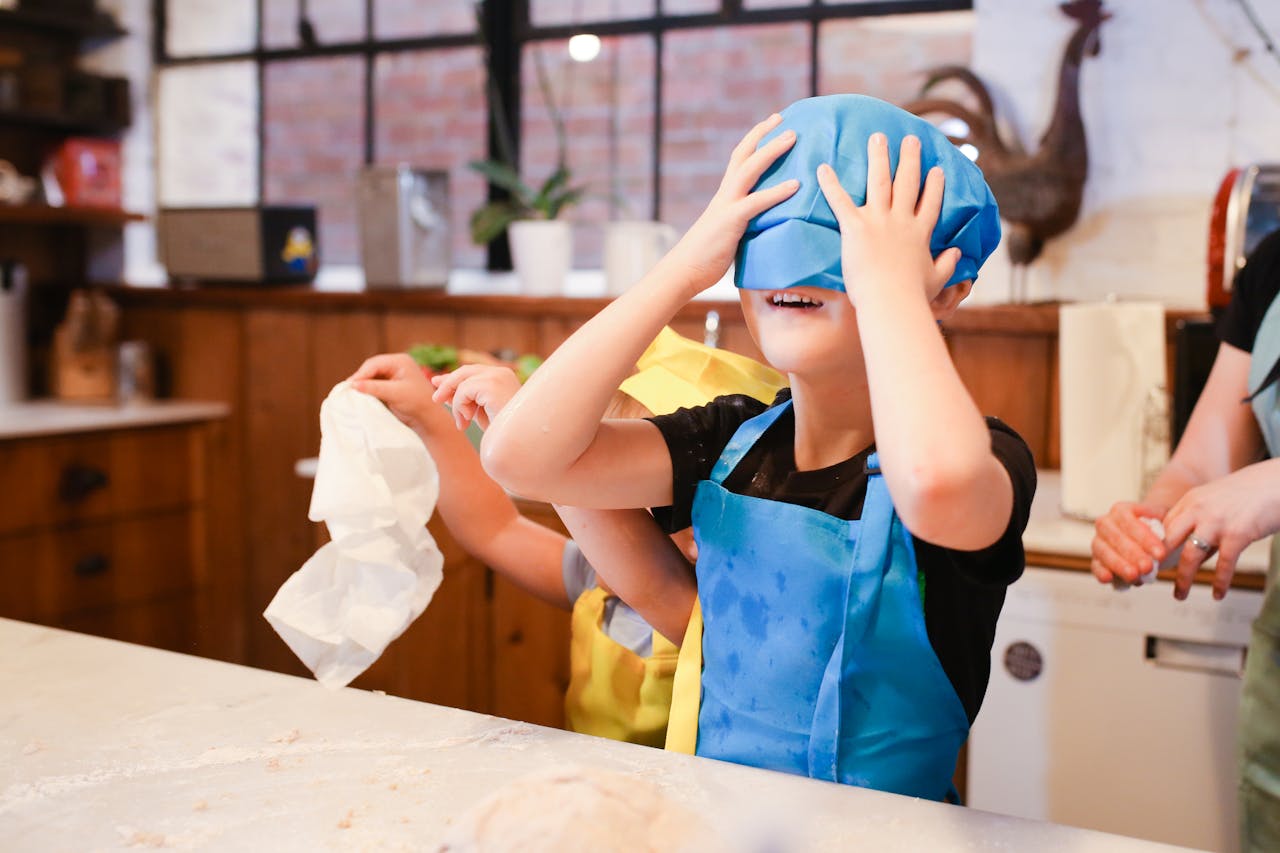 Home Kids enjoy a playful cooking session in a cozy kitchen, learning and laughing.